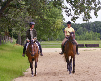 two women talking while riding their horses